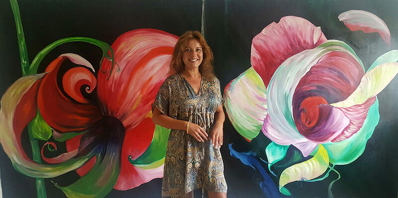 Ramona Romanu vor zwei ihrer Bilder mit floralen ...