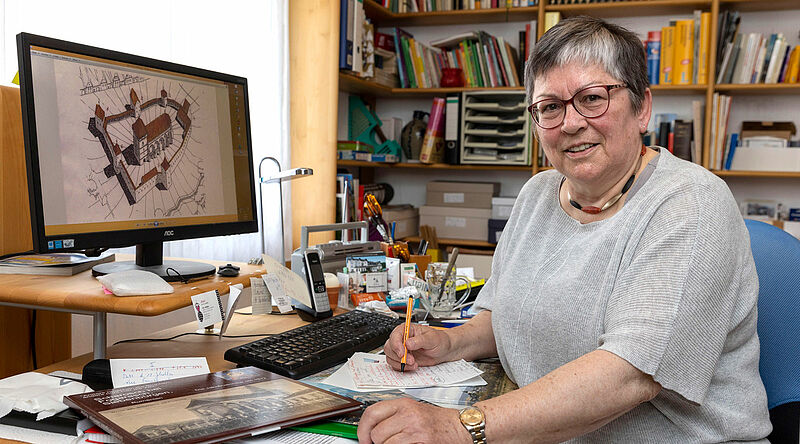 Von ihrem Schreibtisch aus organisiert und ...