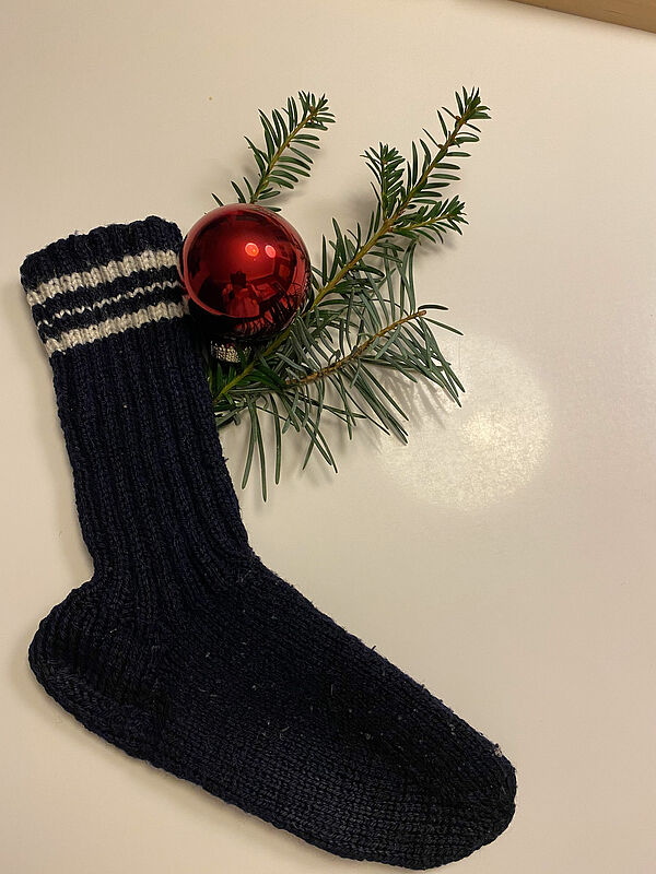 Gestricktes Weihnachtsgeschenk: ein Wollsocken, ...