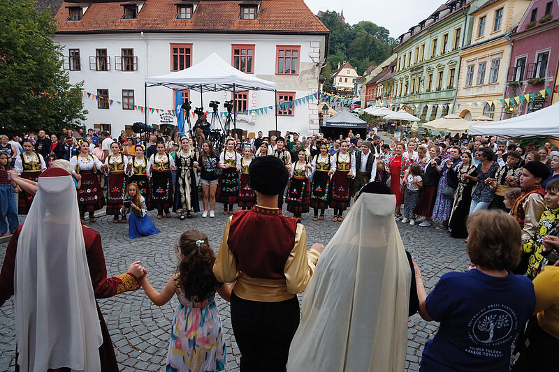 Tanzgruppen und Zuschauer im gemeinsamen Reigen ...