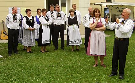 Die Siebenbrger Sachsen aus Coburg besuchen die Nachbarschaft Traun in Obersterreich: der Vorsitzende der Kreisgruppe Dietmar Ehrlich und die Tanzgruppe berreichen ein Gastgeschenk an die Nachbarmutter Irene Kastner.