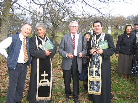 Michael Anders-Kraus (Erster von links) und Horst Gbbel (Dritter von links) bergeben das Buch "Wendepunkt in Nordsiebenbrgen – Punct crucial in Ardealul de Nord" auf dem orthodoxen Friedhof in Treppen an jene Menschen, die heute in den ehemals schsischen Gemeinden Siebenbrgens leben.