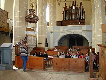 Pfarrer Sattler erlutert der Oettinger Schlergruppe im Inneren der Wehrkirche in Birthlm das Gotteshaus und die Geschichte der Kirchengemeinde.
