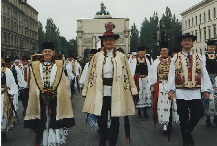 Reumarkter Brautpaar und Gste in schafledernen Trachtenteilen (Krschen, Kirchenmantel, Brustlatz und –pelz) mit bunter Zierstickerei und Lederapplikation. Die Braut trgt an diesem Festtag zum letzten Mal den Borten mit bunten Bortenbndern, der Brutigam das bunte Hutband (spter nur noch schwarz) und das kunstvoll gesteckte „Gepschken“. Im Hintergrund das Mnchner Siegestor. Foto: Petra Reiner