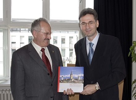 Martin Rill (links) überreicht dem EU-Kommissar für Mehrsprachigkeit, Leonard Orban, den neuen Bildband über Hermannstadt. Foto: Martin Eichler