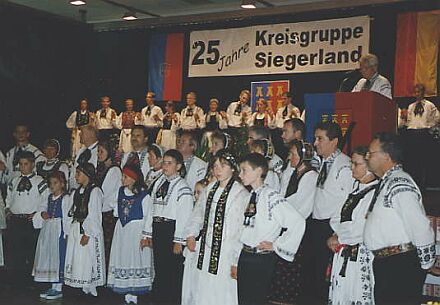 Die Kreisgruppe Siegerland feierte ihr 25-jhriges Jubilum. Im Bildvordergrund: gemischte Tanzgruppe aus Drabenderhhe; am Rednerpult stehend: Vorsitzender Kurt Schuster; auf der Bhne: Tanzgruppe aus Siegen.