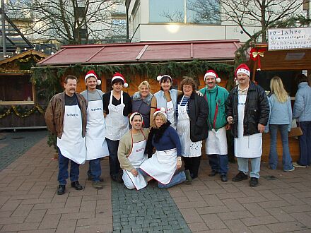 Zehn Jahre Baumstriezelbacken auf dem Christkindlmarkt in Waldkraiburg, von links nach rechts: Volkmar Zintz, Hans und Melitta Schpp, Karina Fray, Hannelore Zintz, Karin und Klaus Zikeli, Herbert Liess. Untere Reihe: Heinz Fray, Katharina Liess. Nicht auf dem Foto, aber mit im Team: Krista Albrich, Harry Lutsch, Ute und Gnther Mller, Ramona und Daniel Schenker. Im Hintergrund ist "Die lustige Baumstriezelbude" zu erkennen.