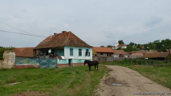 Eine Dorfstrae, und im Hintergrund die orthodoxe Kirche.